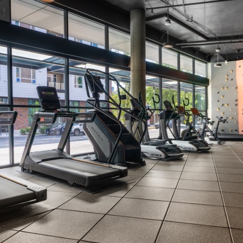 a gym with exercise equipment and rock climbing wall