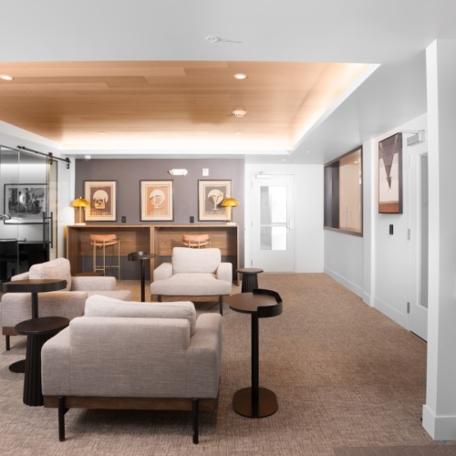 a lounge with seating tables and a coffee machine