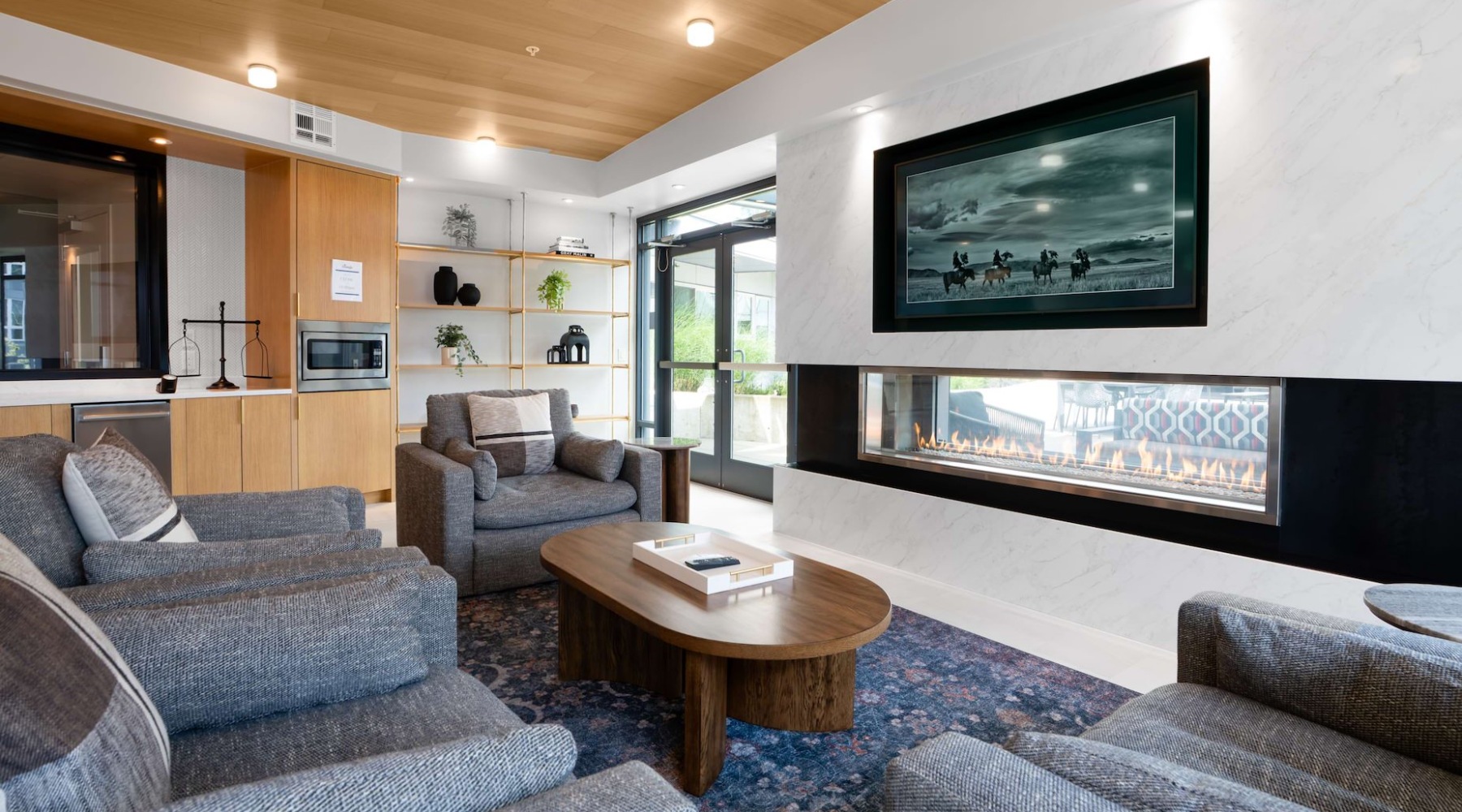 Modern living room with gray furniture, fireplace, and built-in shelving.